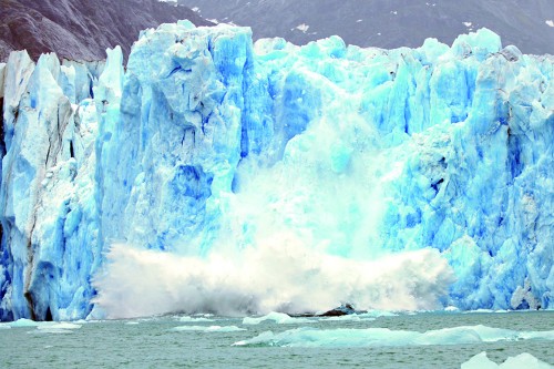 Dawes Glacier calving from the 200 foot high face. Blue ice from highly compressed ice crystals. Tongass National Forest, Alaska, USA.