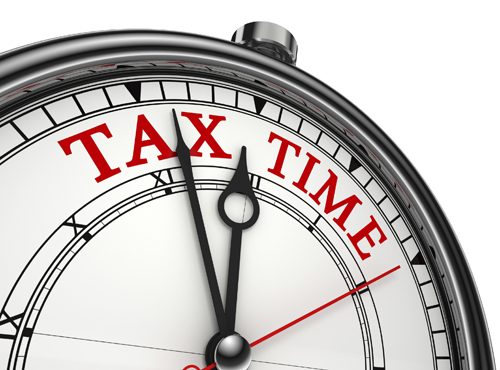 tax time concept clock closeup isolated on white background with red and black words